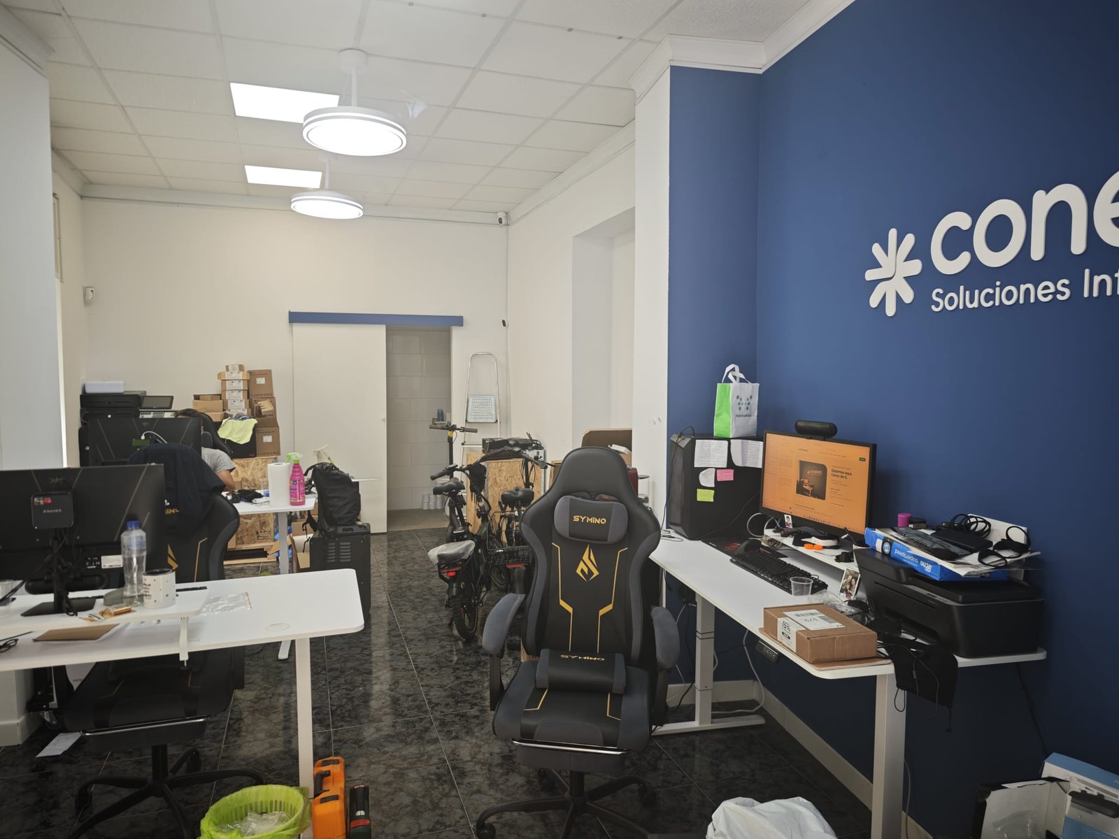 Interior de la oficina de Conexa, con el rótulo de la marca en su pared azul
